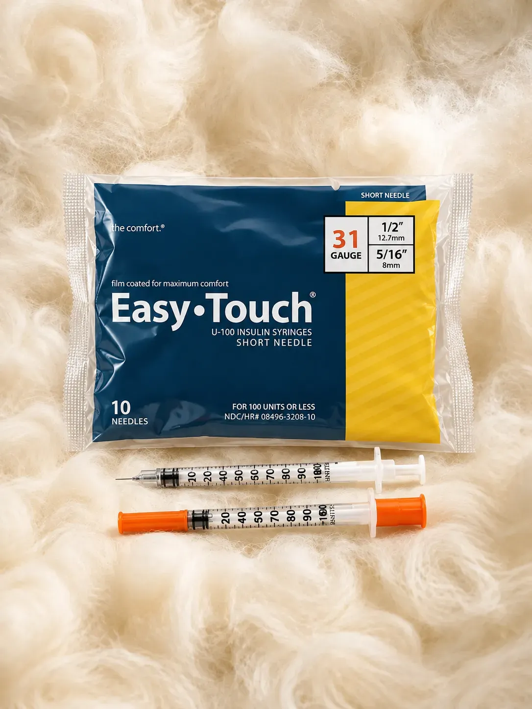 Veracue 10 Needles pack: sealed clear bag with a navy blue and yellow label reading 10 needles, 31 gauge and short needle, with two syringes laid below it, one with an orange needle cap, on cream wool